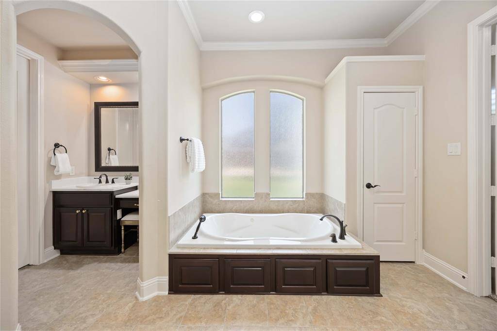 A jetted tub with long windows creates a luxurious and inviting atmosphere, perfect for relaxation and unwinding.