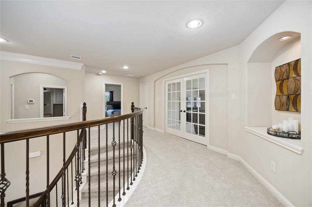 Perspective of the stairwell and game room as seen from the desk area.