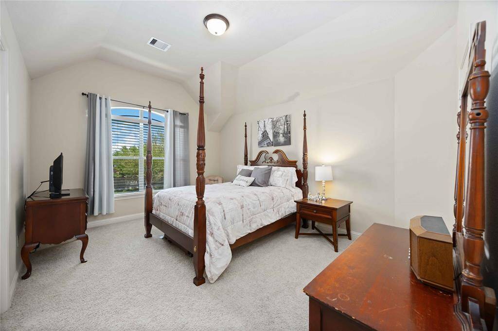 2nd bedroom featuring an ensuite bathroom with stand-up shower, a walk-in closet and ample lighting.
