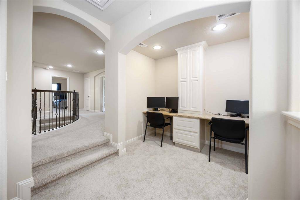 The upstairs includes two distinct desk areas, complete with cabinetry and storage space.