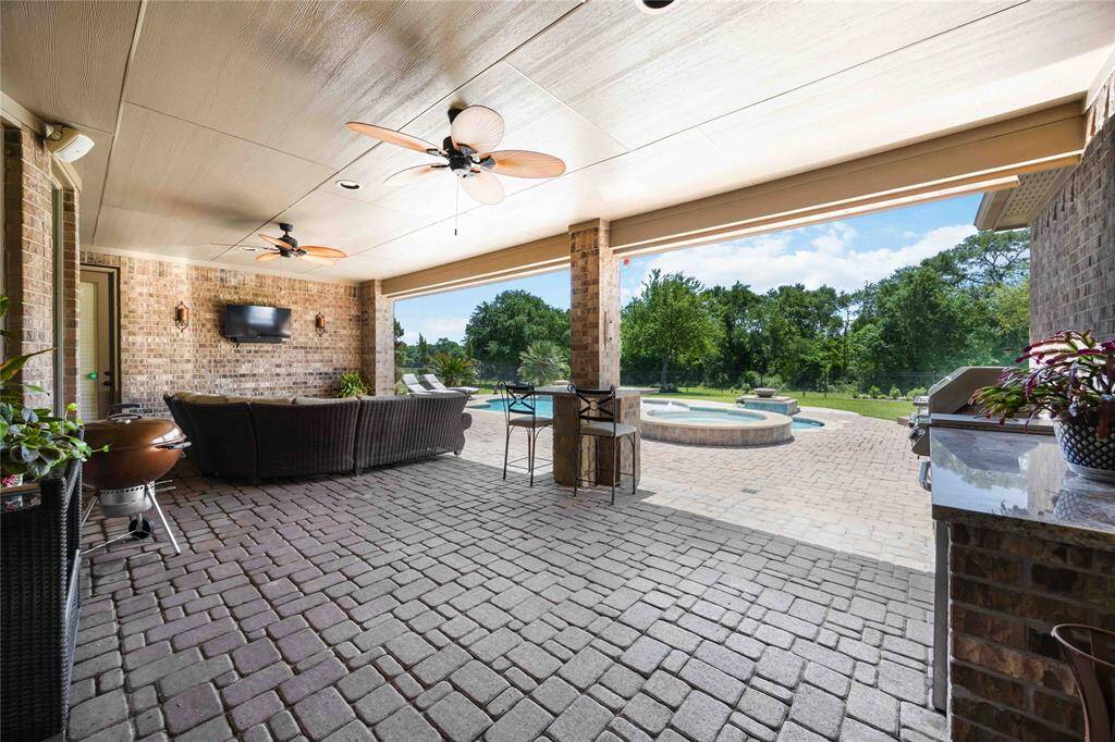 Perspective of the patio, pool, and backyard from an alternative angle.