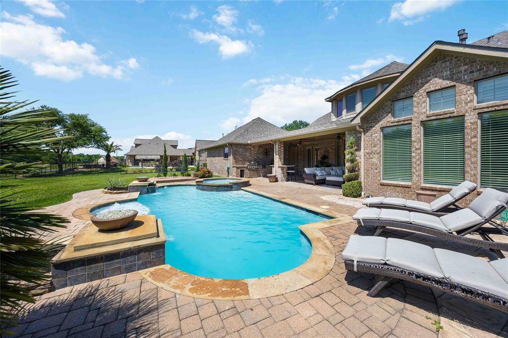 Backyard with a different view of the pool, attractive landscaping, and decorative touches