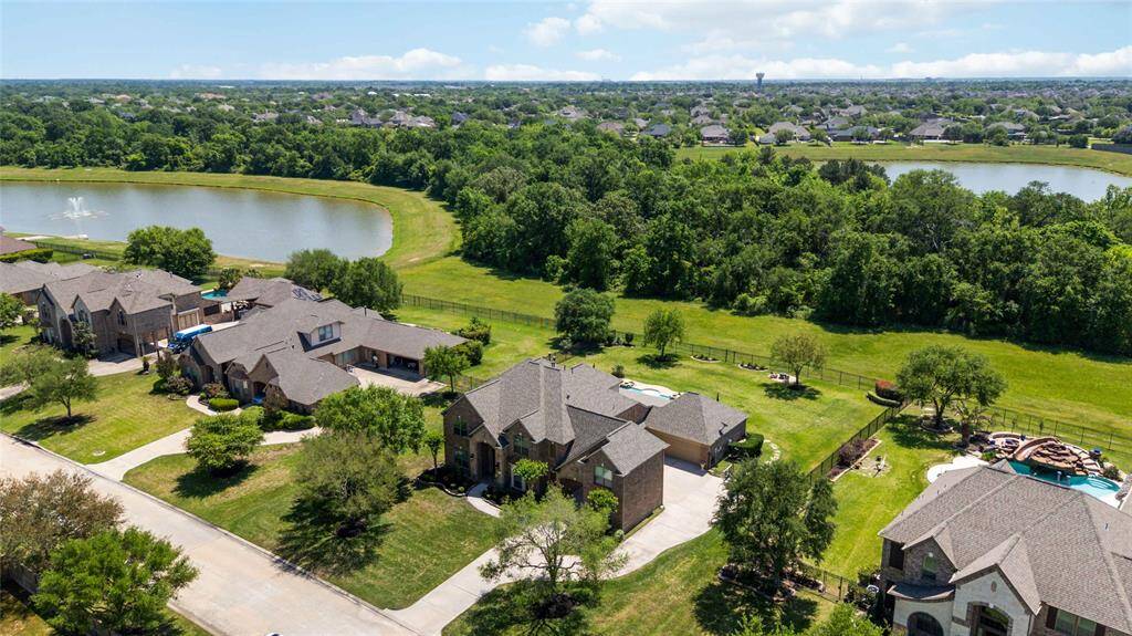 This perspective showcases a drone's eye view of a house, set against a backdrop of a lake and trees.
