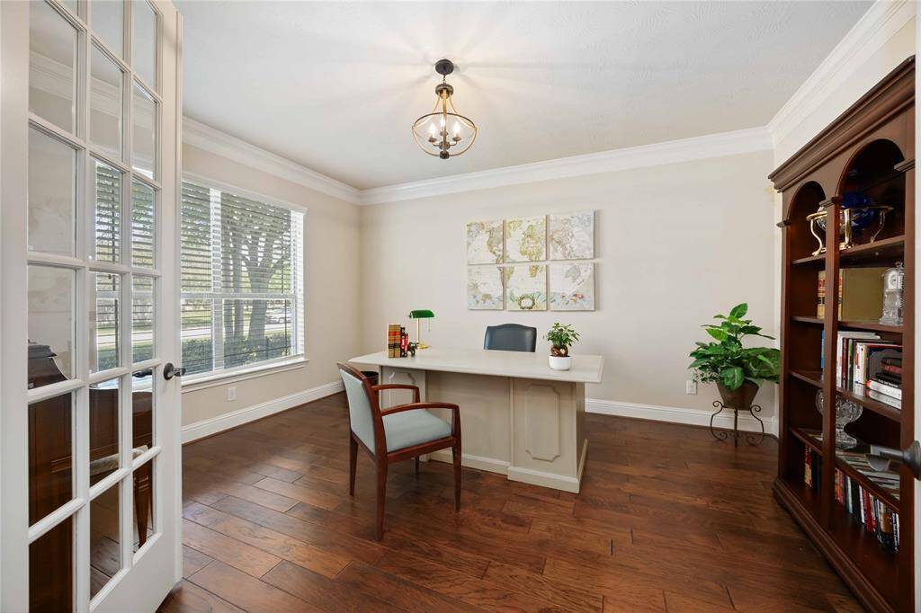 The study is spacious and well-lit, featuring elegant hardwood floors.