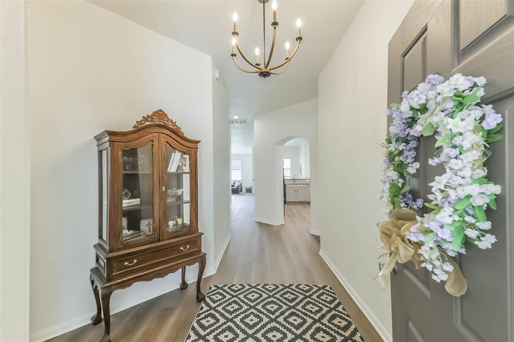 Inviting entryway with elegant chandelier, stylish decor, and a welcoming atmosphere.