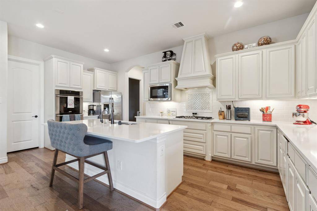 Stunning kitchen with large quartz island with breakfast seating for four.