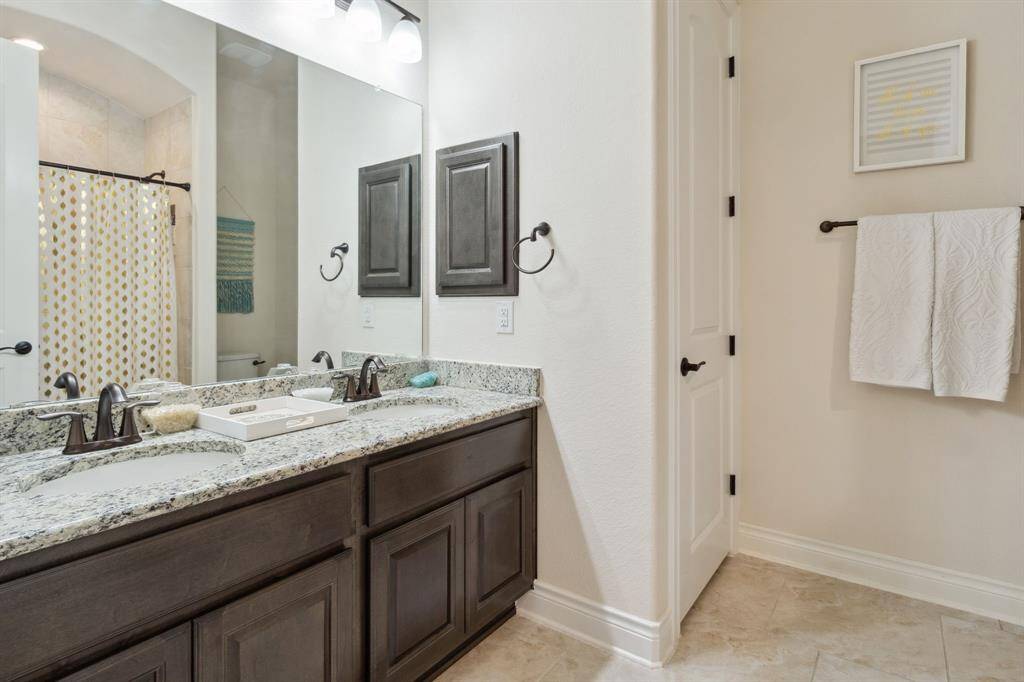 Guest bathroom with dual sinks and tub/shower combo.