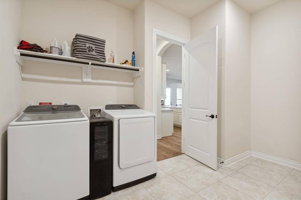 Large utility room with electric or gas dryer connections, shelving and plenty of room to build out the mud room when entering from the garage.