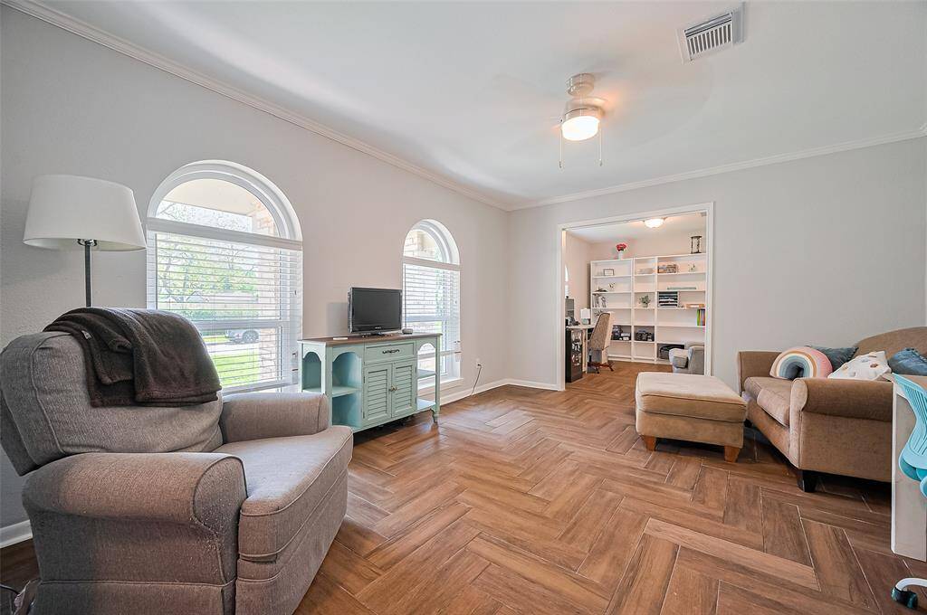Formal living room currently used as a game room/study room. Wood looking tile floors.