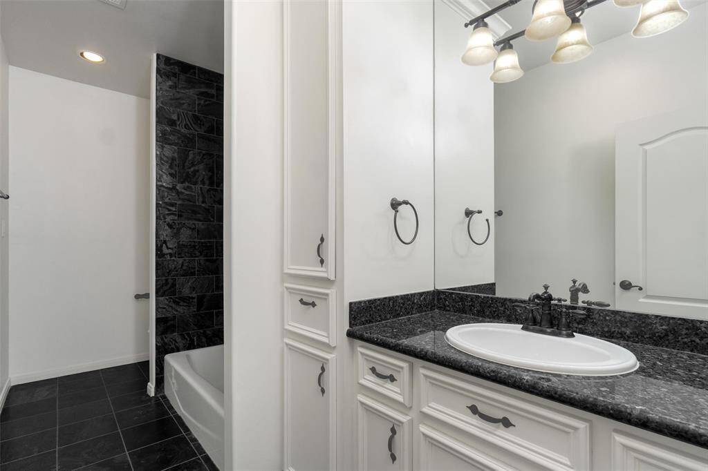 Second full bath downstairs with fully tiled tub/shower combo. Custom storage.
