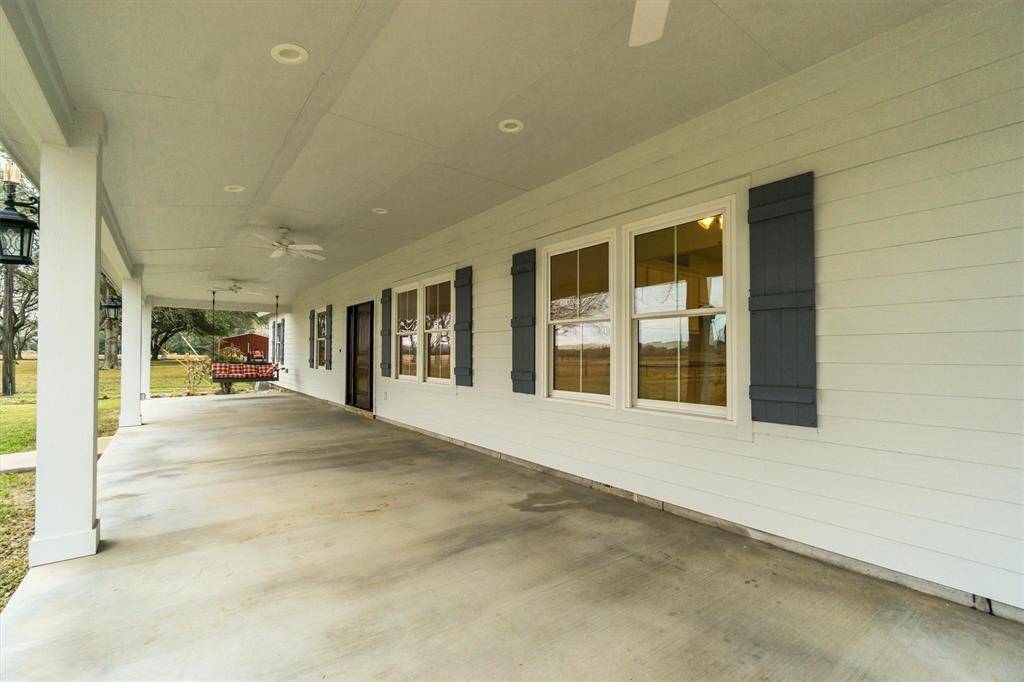 Texas-sized covered patio, overlooking the front yard and large oak trees with swings.