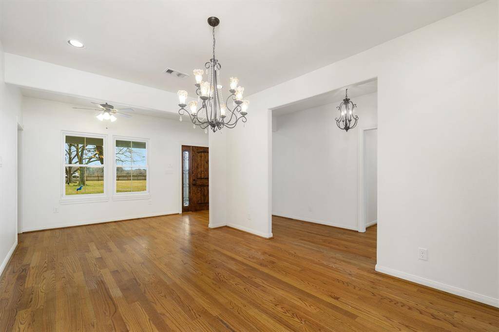 Dining space adjacent to the foyer/entry hall. Windows overlooking front of the property, and Texas-sized front porch