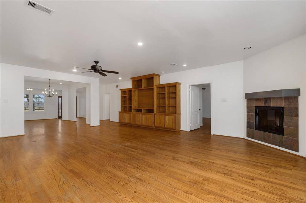Open floor plan, looking from back door, through the living and formal dining, to the front door. Hard wood floors in the living room, cozy corner fireplace and recessed lighting.