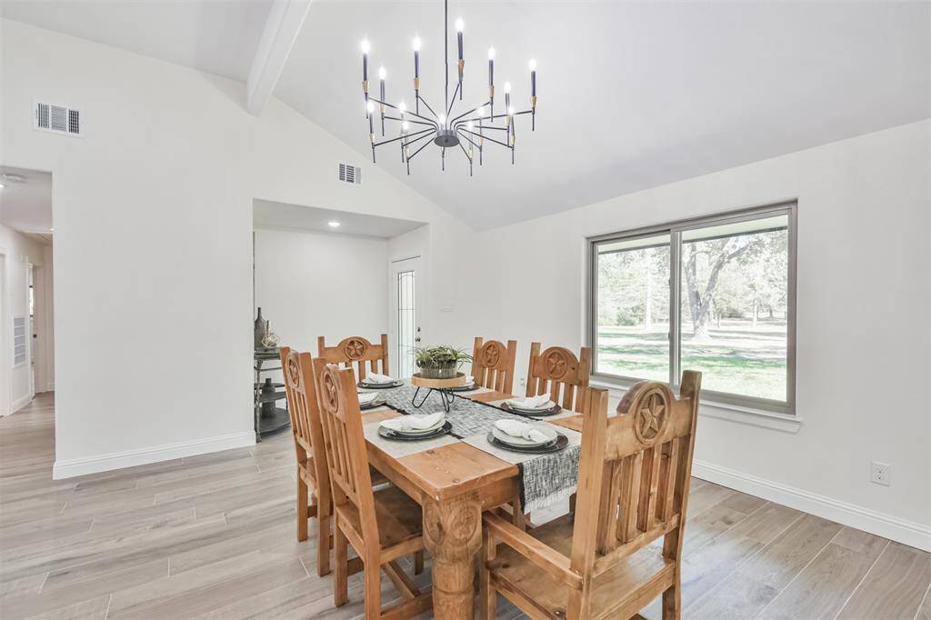 Dining Room features chandelier and large new windows with views for days of the mature pine trees outside.