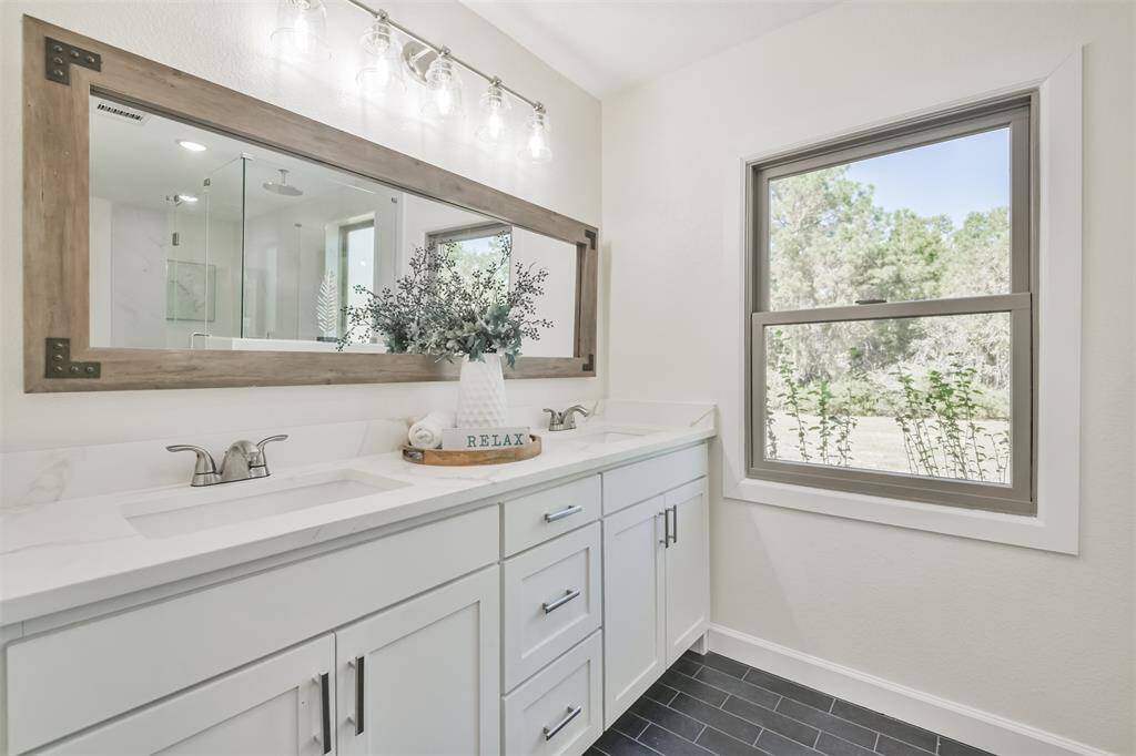 Modern style  mirror, quartz counter tops, undercount sink, all new cabinets with hardware and farmhouse light fixtures.