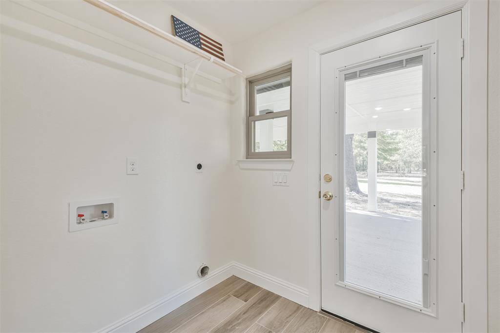 Spacious utility room with built in mini blind back door leading to the patio/backyard.