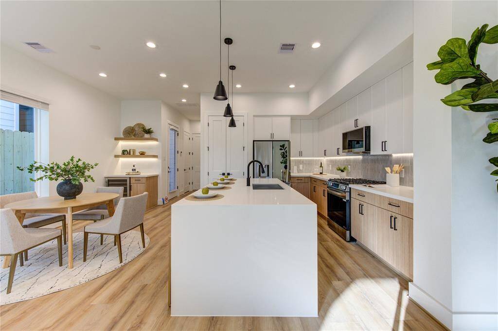 Chef's kitchen with designer tile selections, white quartz counters with 2" thick waterfall island, soft close European style white oak and white slim shaker cabinetry, stainless steel smart appliances, and tons of natural light.