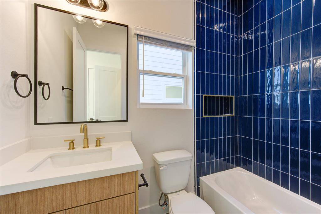 Bathroom 3 is attached to Bedroom 2. All bathrooms feature designer tilework, European style white oak colored cabinetry, white quartz counters, and champagne bronze delta shower fixtures.