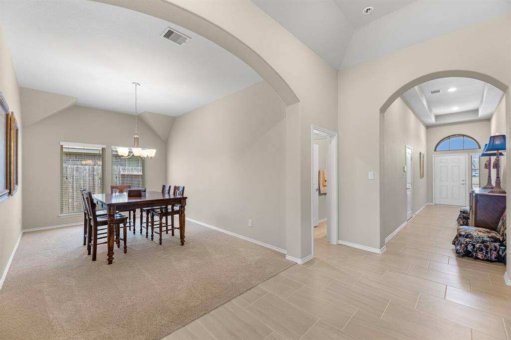 View from the main hallway looking back to front door, formal dining room, and a separate bedroom and bathroom guest wing.