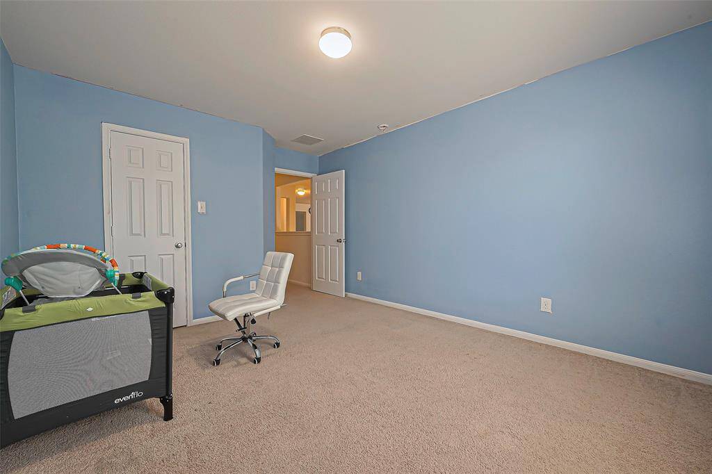 Vibrant yet soothing, this spacious bedroom is ideal for play, rest, or creativity, with bright blue walls, plush carpeting, and ample natural light.