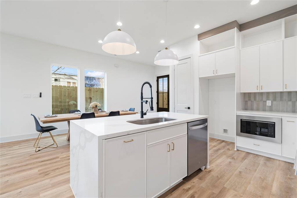 A gourmet chef’s kitchen featuring a sleek, modern design with quartz waterfall countertops on a spacious island, providing both workspace and casual seating.