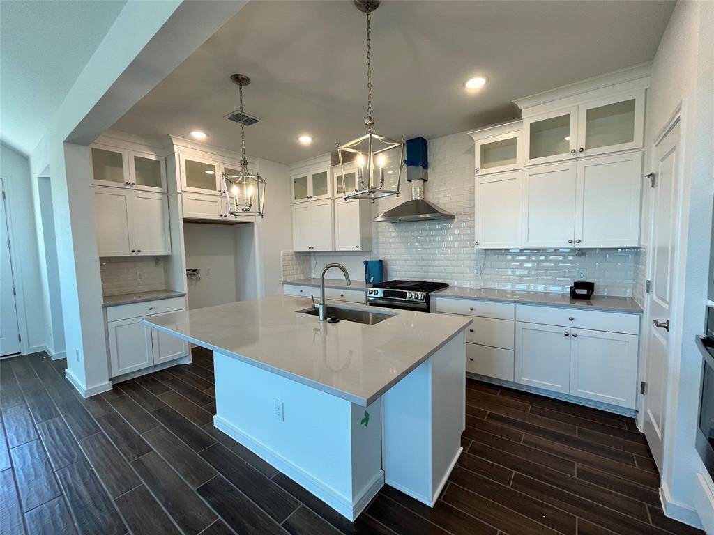 Stacked white cabinets with glass fronts and quartz countertops