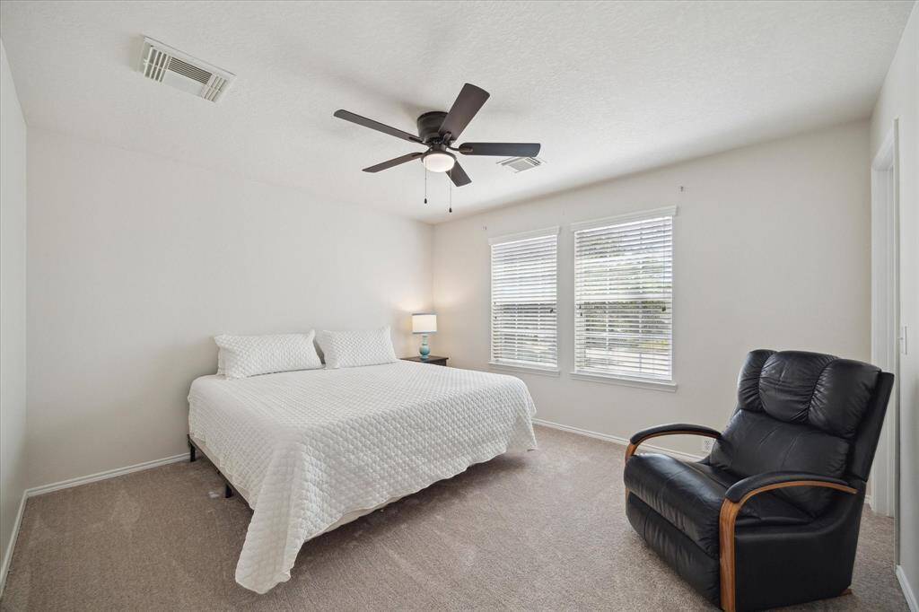 Third bedroom with lots of windows, new carpet, and new ceiling fan.