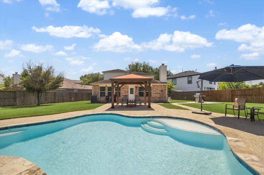 Resort pool (only 4 years old) with with tanning ledge, and water fountain features. Four post shade cover with tin roof. BBQ grilling area off to the side.