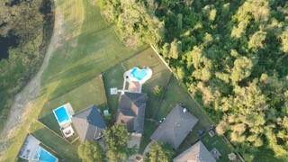 Drone shot showing some of the forest behind the home.