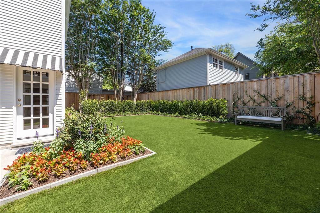 Yard view and professional landscaping. All fences have been replaced. Trellis vines on east side and ivy is on west driveway side. Black and white awning is the entrance to garage apartment.