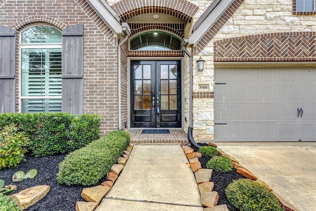 As you approach, the home's exceptional curb appeal immediately catches your eye, with its flawless landscaping and a stunning brick and stone façade. This traditional home boasts a masterful design, highlighted by mature trees and lush greenery, creating a truly inviting and picturesque exterior.