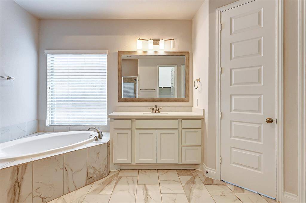 Dual vanities provide separate areas for your daily routines, each offering generous cabinet and counter space, large framed mirrors, and elegant vanity lighting that creates a soft, inviting glow.