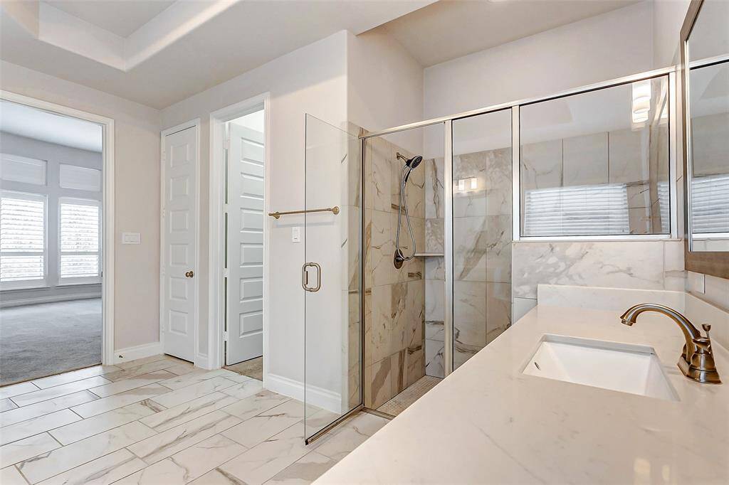 A spacious walk-in shower, designed with both style and function in mind, offers the ideal spot for a rejuvenating rinse after a long day.