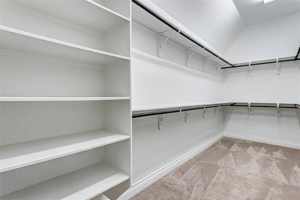 To complete the experience, the primary closet is a dream come true—featuring large shelves and tiered rods that offer abundant space for organizing your seasonal wardrobe and accessories, making it both a practical and luxurious addition to this bathroom sanctuary.