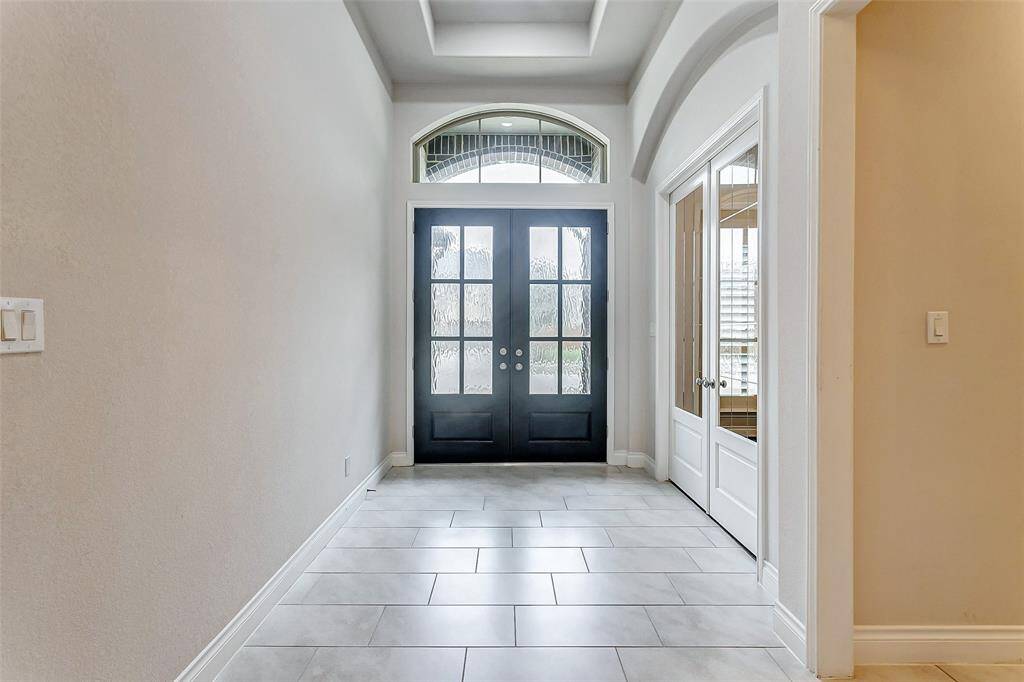 Take note of the breathtaking 8-foot French doors, showcasing elegant rain glass windows that offer both style and privacy. Above, a large transom window adds a touch of sophistication, allowing even more natural light to flood the space and enhancing the overall aesthetic.