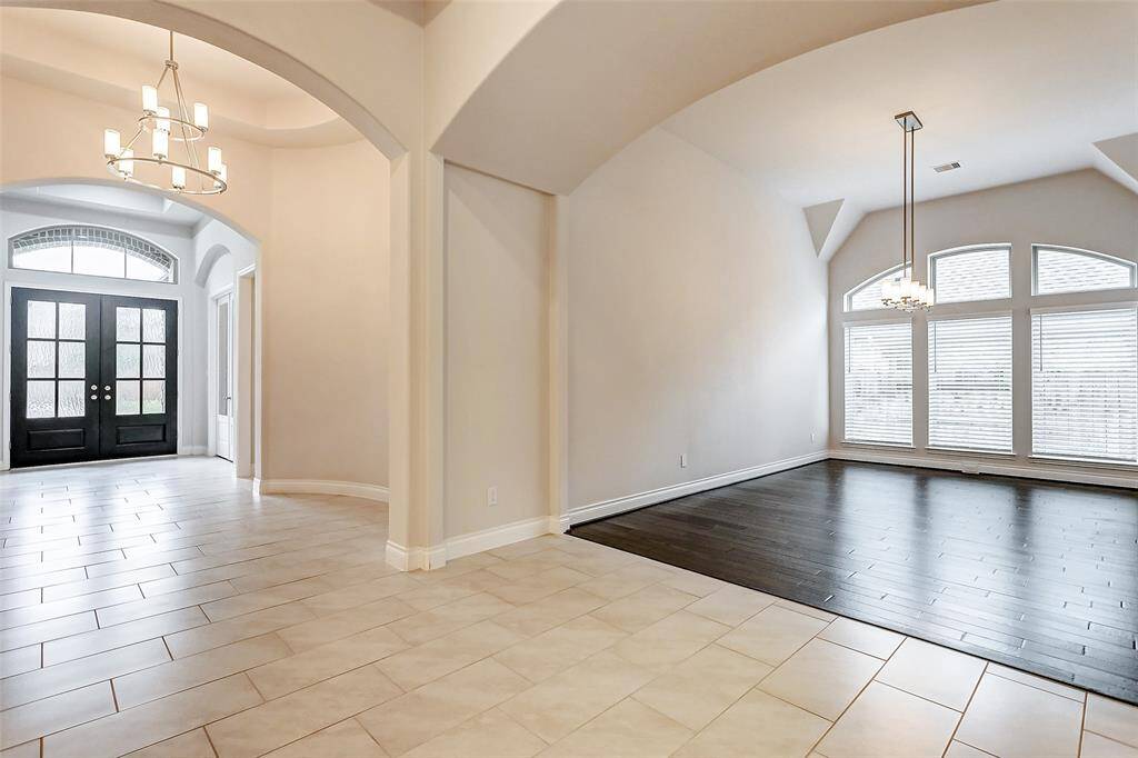 Continue through the extended entry, and you'll find a spacious formal dining room, perfect for hosting your next extravagant gathering. Its sophisticated ambiance sets the stage for memorable meals and celebrations.
