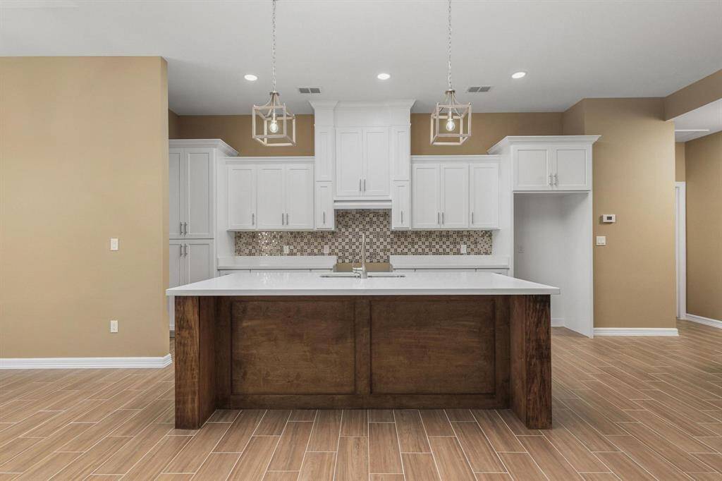 The modern kitchen, open to the great room, showcases professional chef's taste.