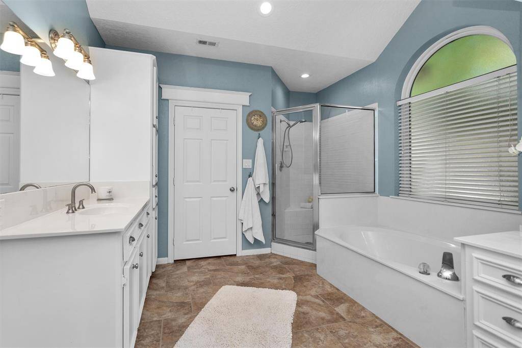 Enjoy dual vanities, granite finishes, and a relaxing soaking tub in this spa-like primary bathroom. A separate shower adds convenience and style.