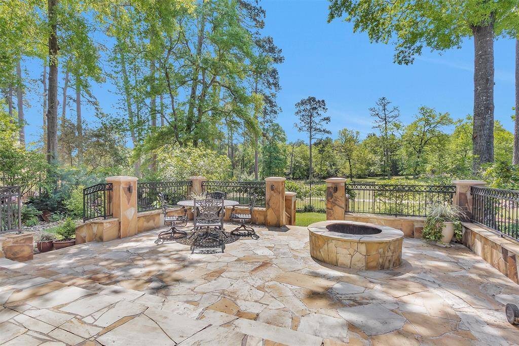 Stunning flagstone patio with a cozy firepit—ideal for evening gatherings or peaceful mornings. The greenbelt view enhances the sense of serenity.