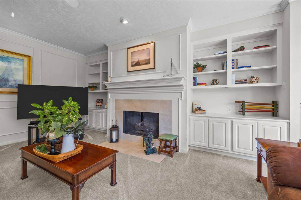 Charming living room featuring built-in storage and a cozy gas log fireplace.