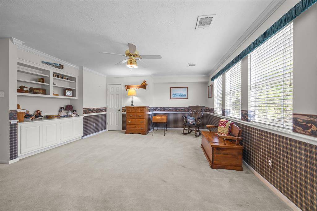 Bright game room with built-in shelving and abundant natural light.