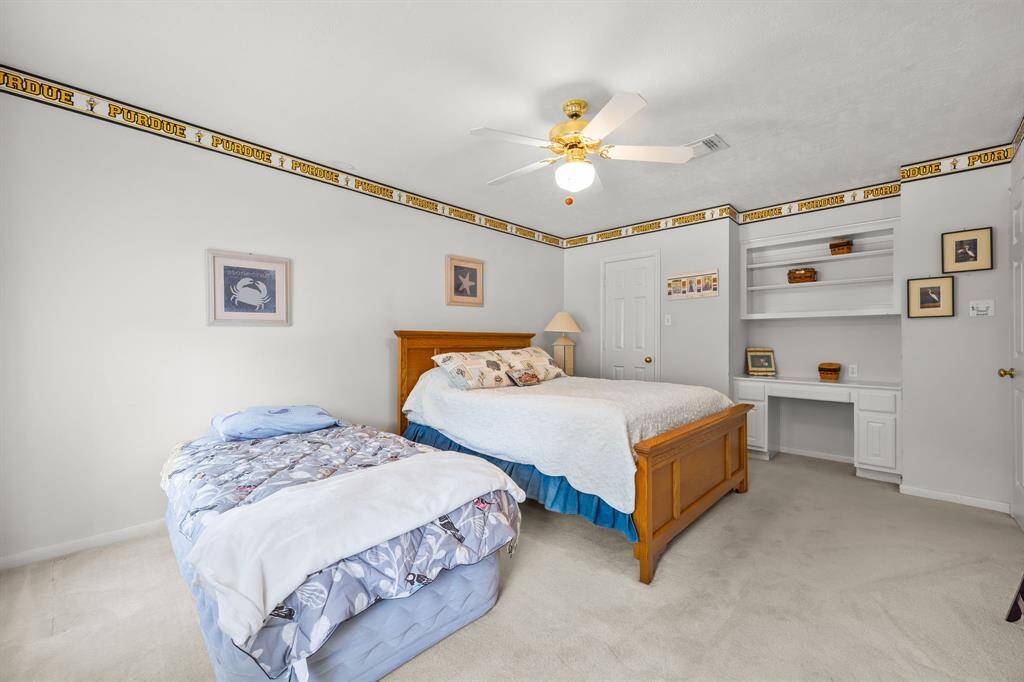 Spacious fourth bedroom featuring a built-in desk and ample shelving.