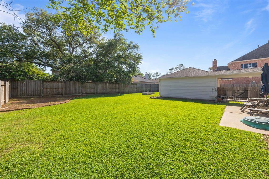 Enjoy unforgettable summer gatherings in this expansive backyard oasis.