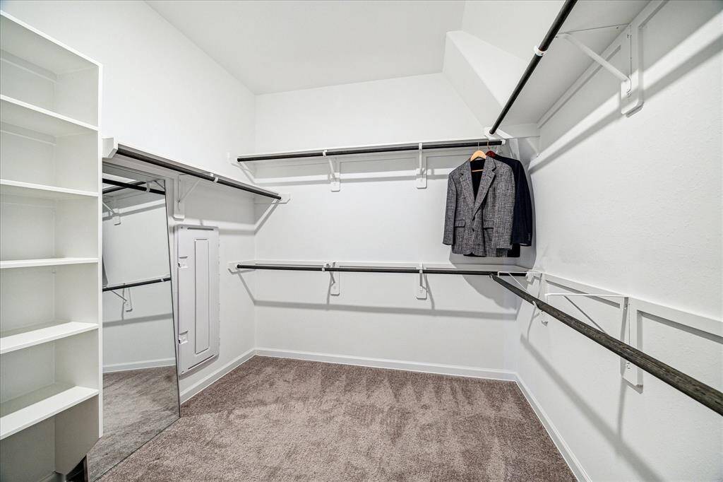 The sizable walk-in closet features built-in shelving.