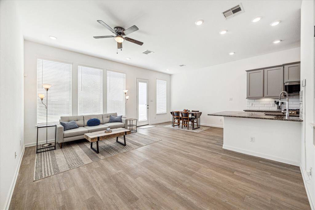 The first floor features high ceilings, tall windows, and luxury vinyl plank flooring throughout.