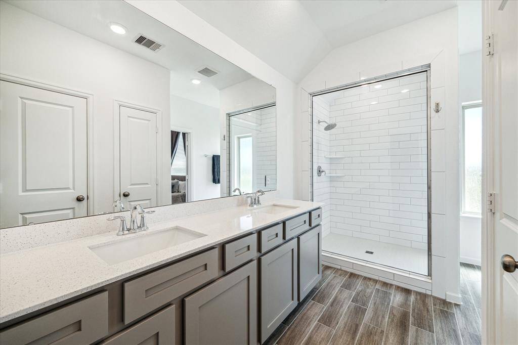 The primary bath features an oversized walk-in shower, water closet, linen closet and access to the large walk-in closet.