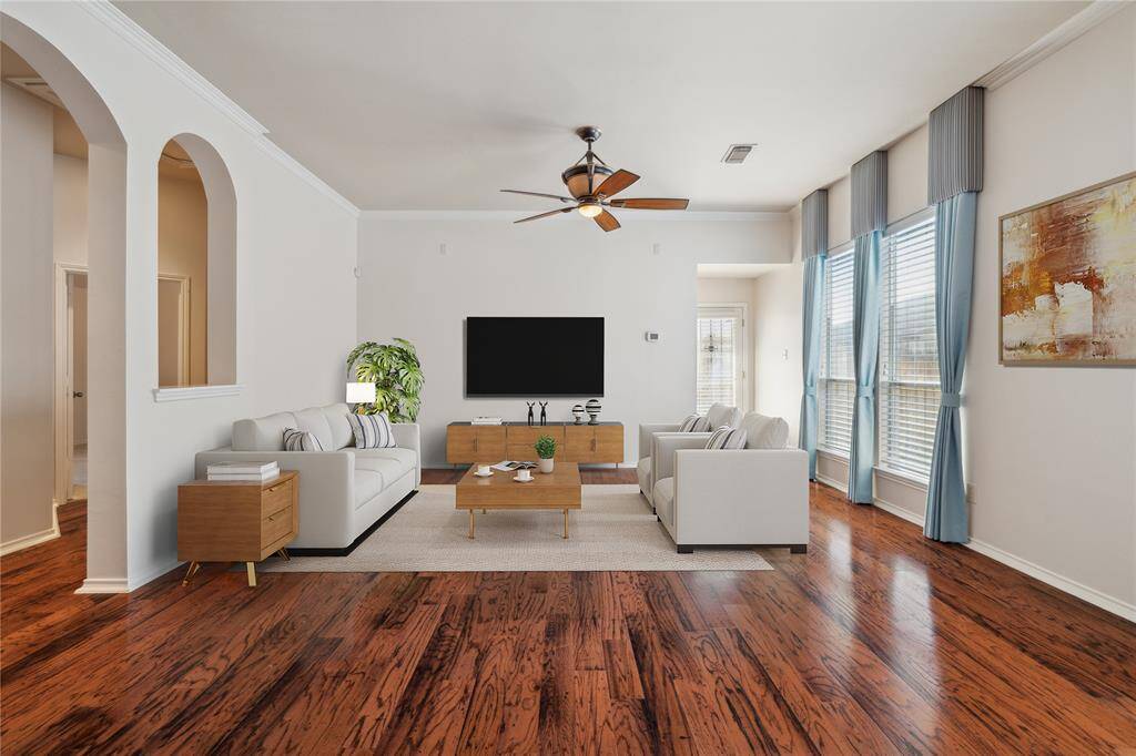 The living room is bright and airy, featuring arched walkways that lead into a versatile game or media room—adding flexibility and charm to the open layout.** Virtually Staged