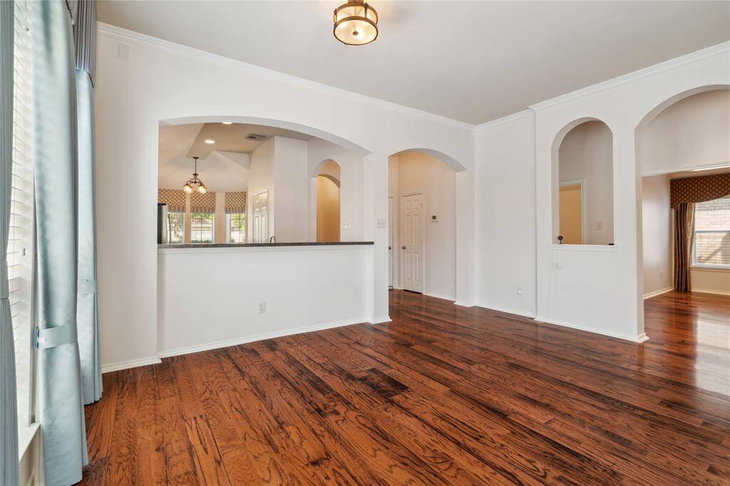 Another view of the formal dining room, highlighting the elegant arched hallway that leads to the versatile game or media room.