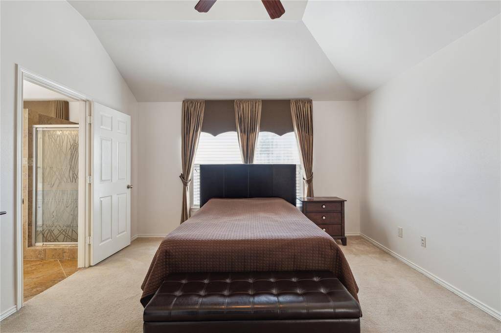 Spacious and serene, the primary bedroom offers plenty of room to unwind, with soft carpeting underfoot and natural light filtering in.