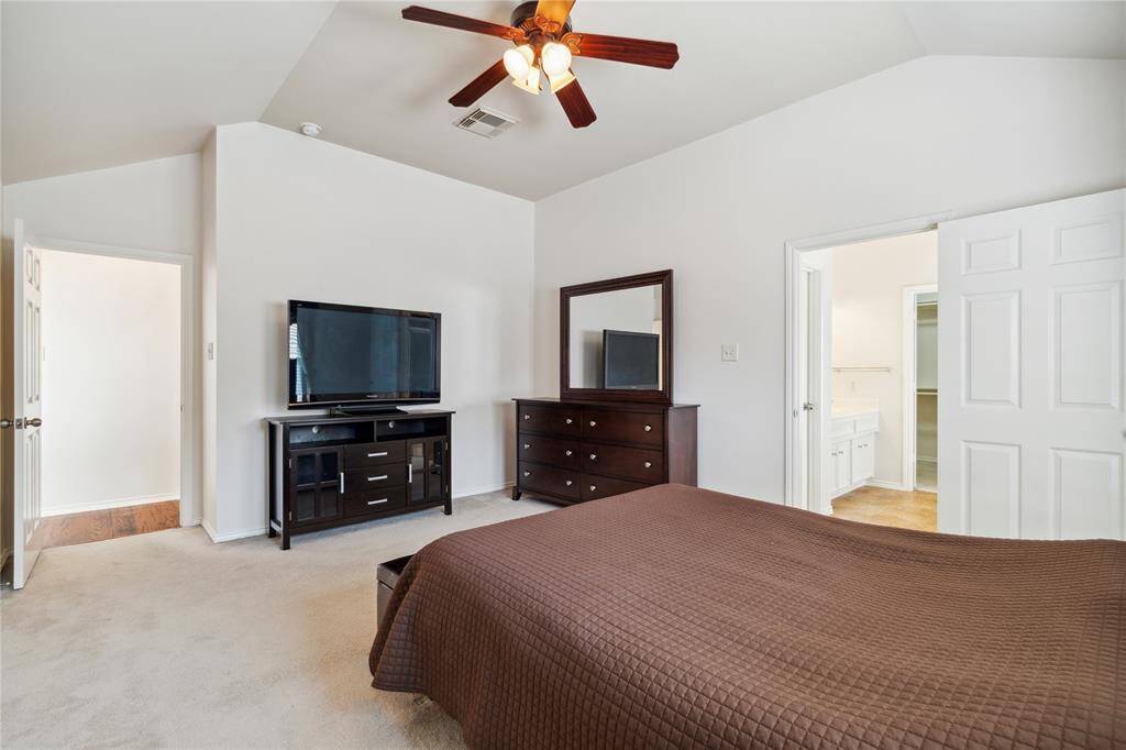 Another angle of the primary bedroom highlights the vaulted ceilings and ceiling fan—adding comfort and air flow to this cozy retreat.